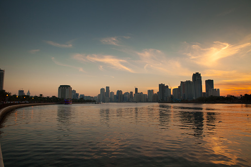 Evening time, sunset over the skyline of the city of Sharjah, United Arab Emirates. View from Blue Souk over the Lake Khalid.