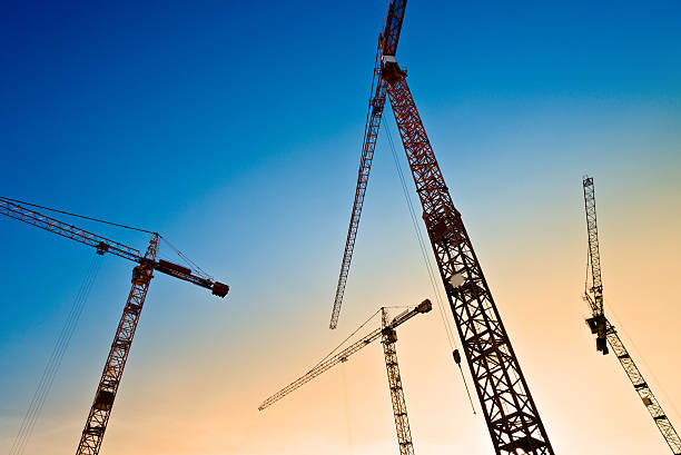 istock four tower cranes on the blue sky 530948742