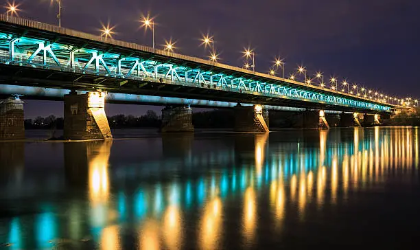 Highlighted bridge at night and reflected in the water.Bridge Gdanski