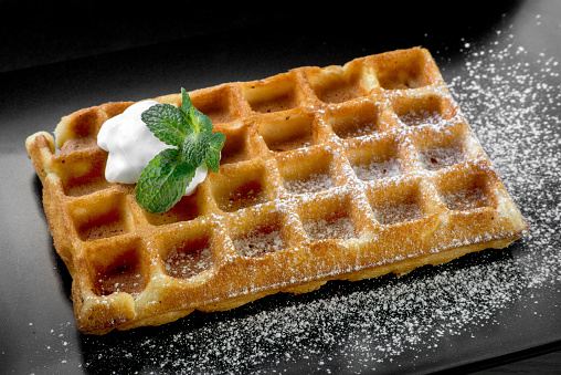 Belgium waffle with mint on black plate