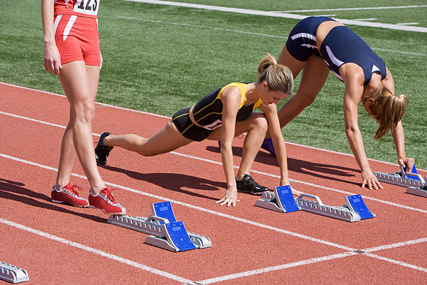 Female athletes warming up next to starting blocks