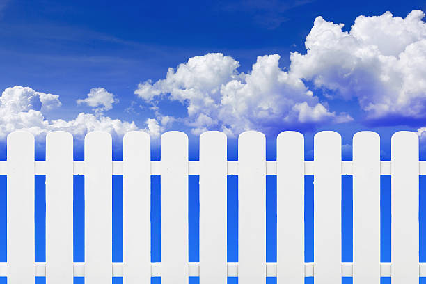 istock White fence against the cloud. 530964123