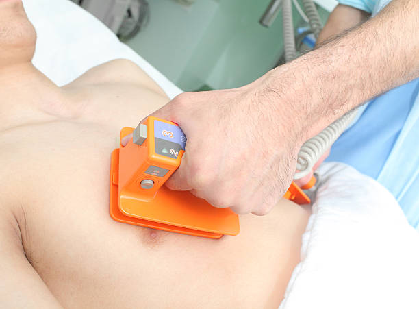 istock Doctor makes the patient an electric defibrillation 530970671