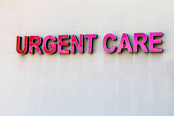 Red urgent care sign on beige wall Signage for Urgent Care, red elevated letters against beige wall.  Exterior sign.  Urgent care is a commonly used part of the healthcare system in the United States. emergency medicine stock pictures, royalty-free photos & images