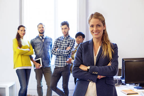 istock Successful young woman at office with team in background 530973513