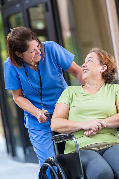 istock Nurse talking to patient while pushing her in wheelchair 530983157