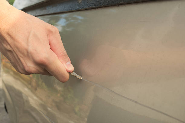 Male hand scratching a car Male hand scratching a car by using silver key revenge stock pictures, royalty-free photos & images