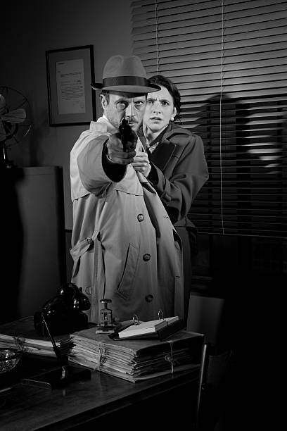 istock Detective protecting a young woman pointing a gun 530983694