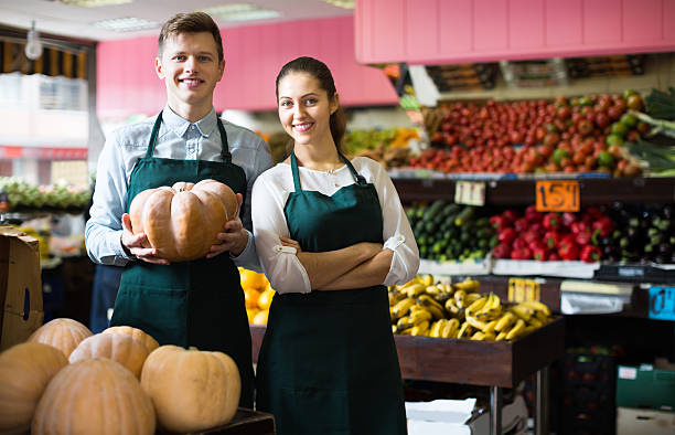 Sellers posing with big pumpkin