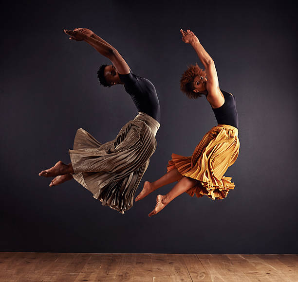 Synchronisity Two contemporary dancers performing a synchronized leap in front of a dark backgroundhttp://195.154.178.81/DATA/shoots/ic_784287.jpg performing arts event stock pictures, royalty-free photos & images
