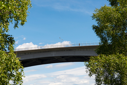 Stockholm, Sweden - June 17, 2015: A man walks across a bridge on a summer day in Stockholm, Sweden. This is the view from a footpath on Långholmen, one of Stockholm's many islands.