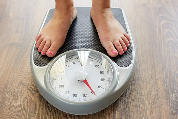 istock Female feet with weight scale 530984752