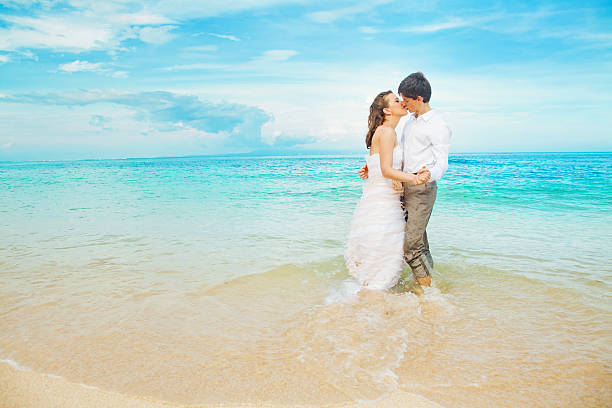 Bride and groom kissing on the beach Bali malay couple full body stock pictures, royalty-free photos & images