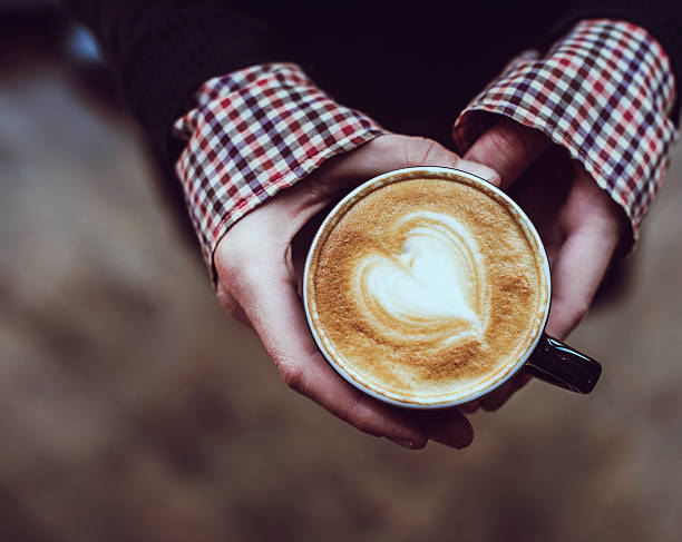 istock Woman holding coffee cup with foam art 530987648