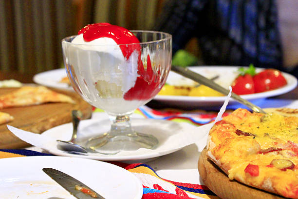 Ice cream poured raspberry syrup and pizza in restaurant