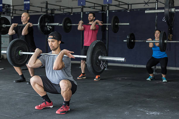 istock Adult male exercising and doing a squat with a barbell 530988556
