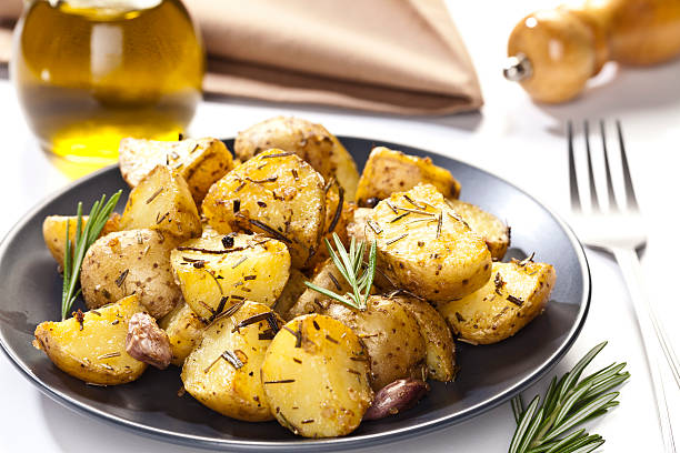 patatas asadas - roasted potatoes prepared potato herb food fotografías e imágenes de stock