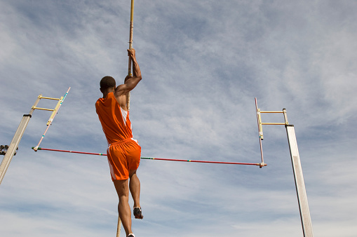 Pole vaulted taking off, low angle view