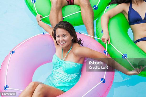 Young Woman On Float In Swimming Pool With Friend Stock Photo - Download Image Now - 18-19 Years, 2015, Adolescence