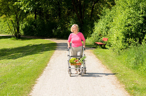 istock Elderly woman using a walker to do her shopping 530998058