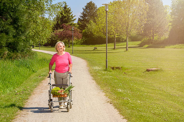 istock Elderly woman using a walker to do her shopping 530998394