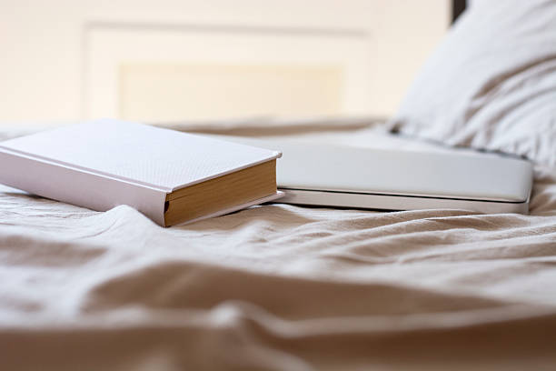 istock Book and laptop in bed 530998430