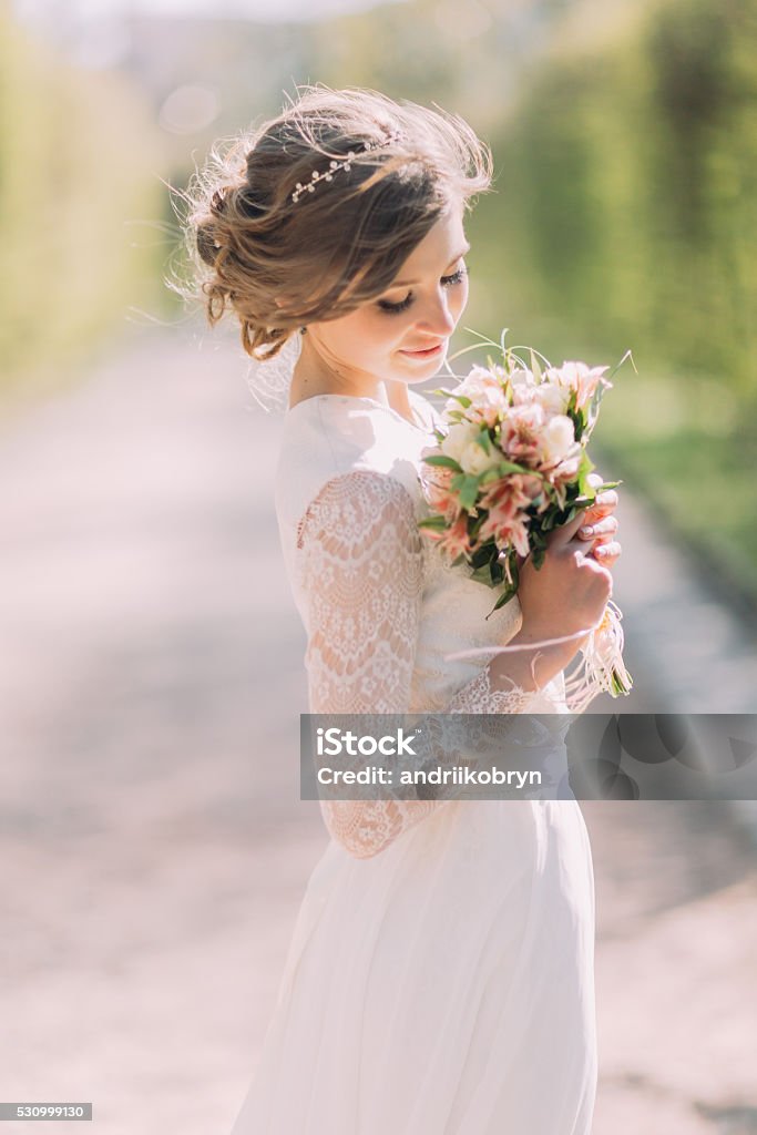 Beautiful blonde bride with bouquet of spring flowers outdoor Beautiful blonde bride with bouquet of spring flowers outdoor. Boho Stock Photo