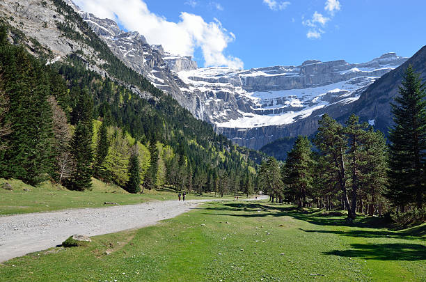 Hiking trail to the cirque of Gavarnie in Pyrenees The pathway goes along the valley to the half-open steep-sided hollow formed by glacial erosion. This is a large rock amphitheater in the French Pyrenees. gavarnie stock pictures, royalty-free photos & images