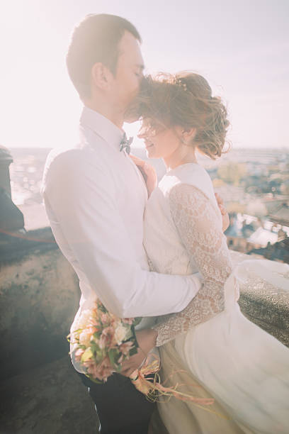 istock Handsome groom gently kissing brides forehead standing on balcony with 530999924