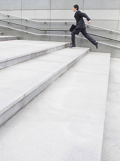 istock Side View Of Businessman Running Up Steps 530999973