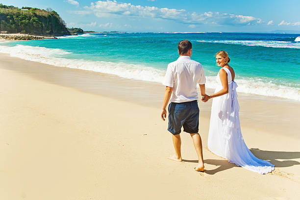 istock Groom and his bride walking on the beach 531000235