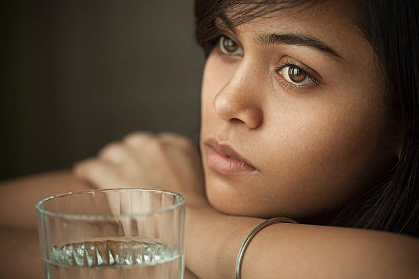 Serene girl thinking and looking away with blank expression.