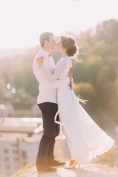 istock Newlyweds touch each other with noses on cityscape background 531002256