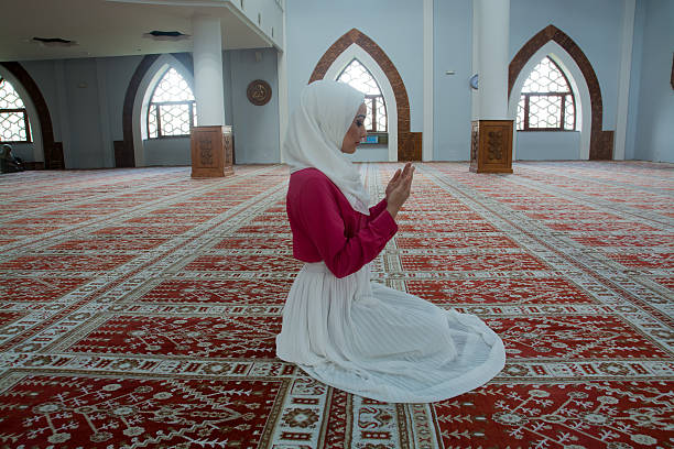 istock Young muslim woman praying in mosque 531003128