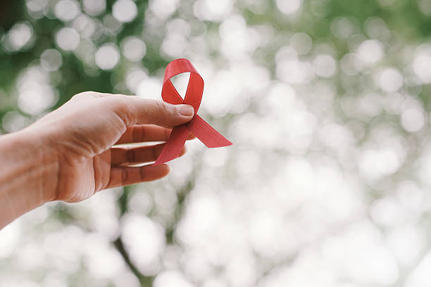 istock red aids ribbon in hand. 531003538