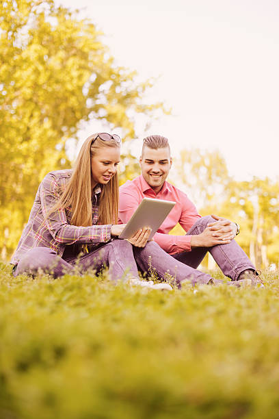 istock Casual couple having daily break in park with digital tablet 531005660