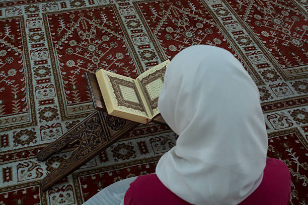 Young muslim woman reading Koran