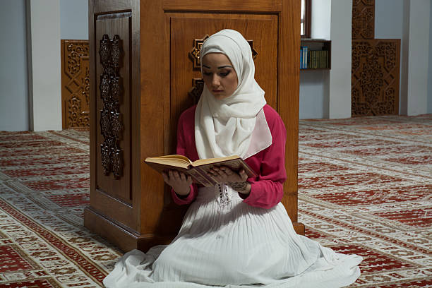 istock Young muslim woman reading Koran 531006480
