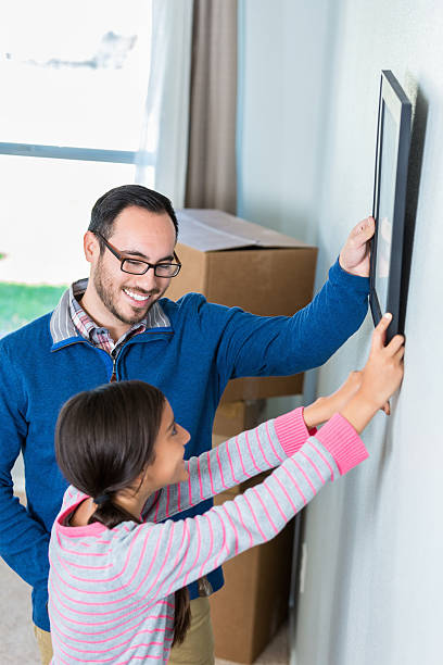 istock Dad and daughter hang photo in home 531006780
