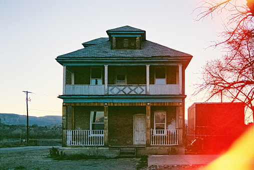 Old Abandoned House taken with 35MM camera against a clear sky with special light imaging coming in from the side.