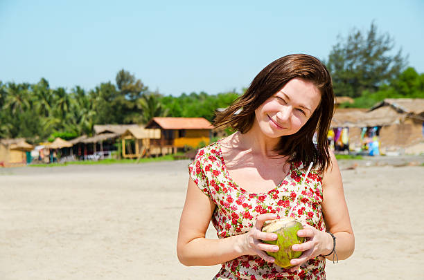 istock Young woman drinking coconut milk on the beach. 531010026