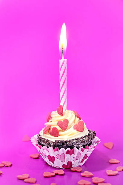 istock Birthday cupcake with candle, on magenta background 531011534