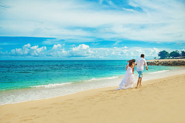 istock Bride and groom runing on the beach 531012467