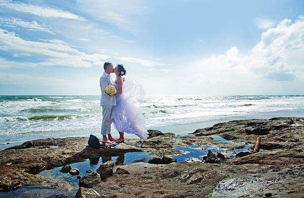 novia y el novio beso en la playa - bride women standing beauty in nature fotografías e imágenes de stock
