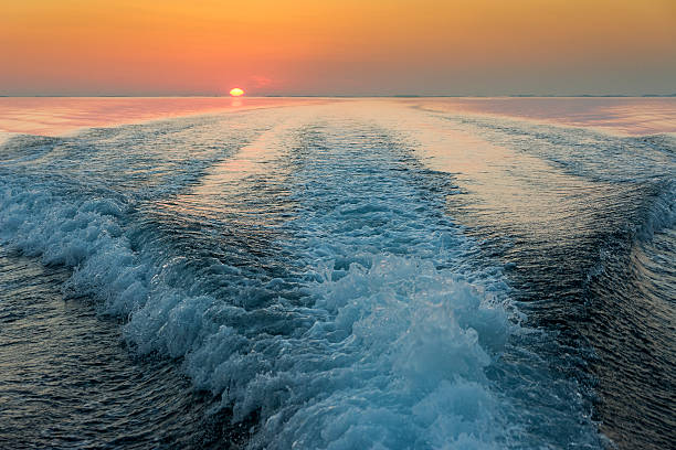 Lancha onda no pôr-do-sol. - foto de acervo