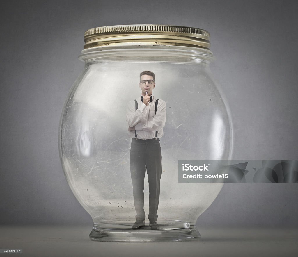 Stuck in the jar An elegantly dressed man is stuck inside a jar Jar Stock Photo