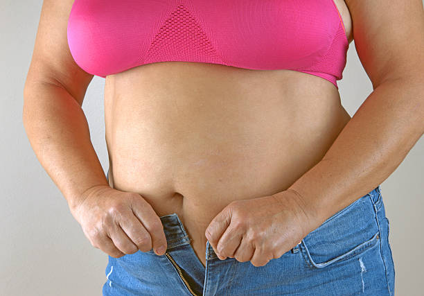 istock woman trying to zipper her jeans 531014155