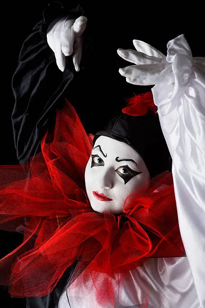 Mime actress in Pierrot costume performing a dance