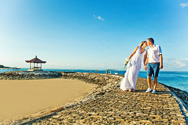 istock Bride and groom walking on the beach 531023027