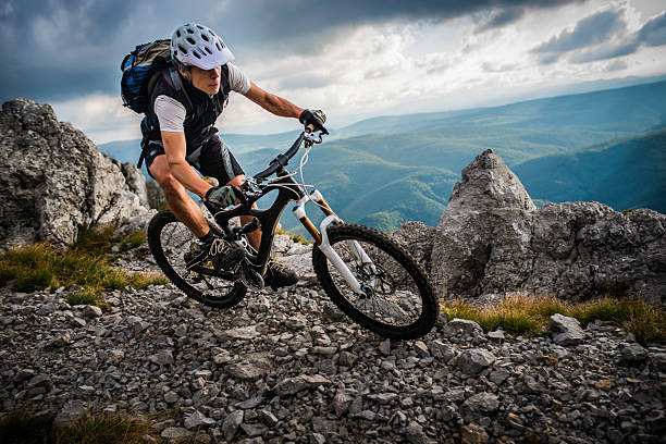 biker riding on a mountain trail - mountain biking extreme sports cycling bicycle стоковые фото и изображения